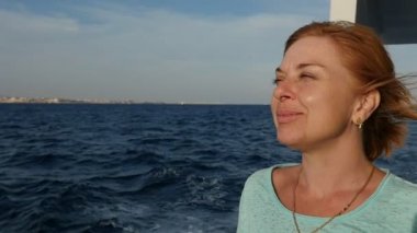 Sarışın kadın gemi Küpeşte Sharm El Sheikh slo-mo heyecanlı görünümünde bir Tshirt ve alıcı rüzgar güneşli günde Mısır'ağır çekimde giymiş turistik gemide seyahat mutlu sarışın bir kadın ayakta ilham