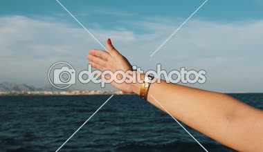 Dalgalı denize slo-mo Inspiring görünümünde bir el Kırmızı manikür ve güneşli bir günde, Sharm El Sheikh yavaş çekimde bir gemide germe bir kol saati ile Mısır'daki bir gemiden dışarı çekerek kadının palm