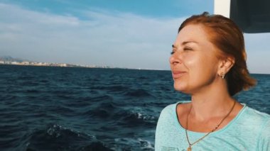 Gülümseyen gemi Küpeşte Sharm El Sheikh slo-mo duygusal bir Tshirt giyinmiş ve bir demiryolu üzerinde güneşli günde Mısır'ağır çekimde eğilerek turistik gemide seyahat mutlu sarışın bir kadın görünümünü ayakta sarışın kadın