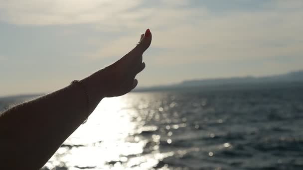 女性の手がはしゃぎ スローモーションで曇り空と見事な夕日でエジプトの輝く海を見渡すその指を回す女性の手の Slo 模陽気なビューで夕暮れ時エジプトの暗い海の上の指を攪拌 — ストック動画