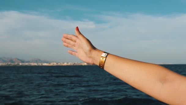 女性の手のひらの赤のマニキュアとスローモーションでシャルム シェイクで晴れた日に船に伸ばし腕時計女性手のスローモーション インスピレーション ビューでエジプトの船から波状の海に抜き — ストック動画