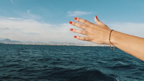 スローモーションで晴れた日のシャルム シェイクに観光船の風を感じるしようとすると 赤のマニキュアとスローモーション女性手の素晴らしい景色でエジプトの船から波状の海に広がる女性の手 — ストック動画