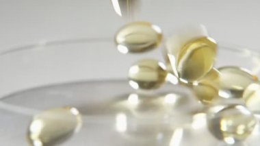 Yavaş hareket slo-mo bir stüdyoda bir şeffaf cam yüzeye düşen altın jöle Kristaller muhteşem görünümü bir stüdyoda bir cam yüzeye düşen altın jelly boncuk. Lüks ve neşeli görünüyorlar.