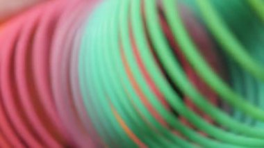 Neşeli gökkuşağı ile unclenching oyuncak bataryaları yavaş hareket yakın çekim shot plastik Rainbow sinsi sinsi aslant yavaşça ile birçok renkli bobinleri ve ruh ilerleme, sevinç ve fest slo-mo şekillendirme