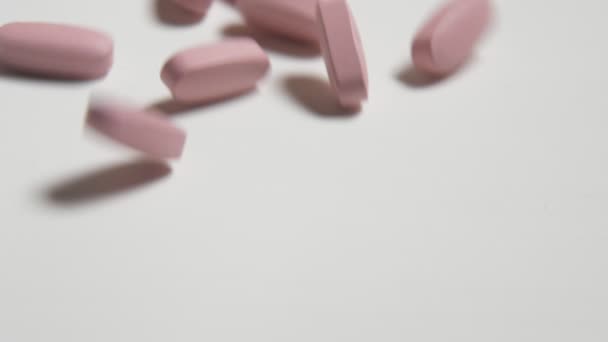Bonnes tablettes dansant, tourbillonnant et roulant sur une table blanche à Montréal- mo Magnifique macro shot de pilules de santé roulant et jouant sur une table de studio blanche à Montréal. Ils forment l'esprit de santé et de joie .
