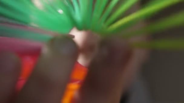 Tuyau coloré flou formé par des bobines slinky arc-en-ciel en plastique au ralenti Plan macro d'un tuyau multicolore tordu flou façonné par des bobines slinky arc-en-ciel en plastique générant l'esprit de joie, optimisme au ralenti 