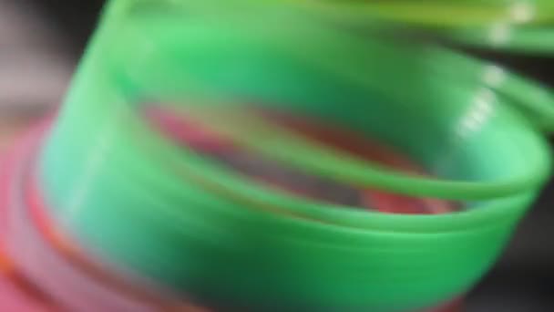 De nombreuses salades et les bobines roses d'un slinky va joyeusement vers le haut à Montréal- mo Macro shot d'un tir arc-en-ciel en plastique levant optimiste avec ses bobines de salade dans le fond noir. Il façonne l'esprit d'optimisme au Vietnam 