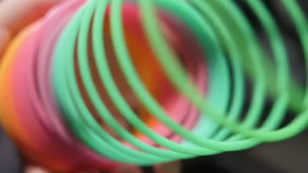 Plastic Rainbow Slinky Unclenching Colorful Coils Slow Motion Macro Shot — Stock Video