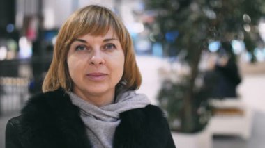 İnanılmaz bir kadın ile slo-mo olumlu neşeli sarışın bir kadın portresi yeşil ağaçların bir siyah ceket ve mutlu bir alışveriş merkezinde slo-mo gülümseyen bir sportif gömlek şık bir saç kesimi ile bir alışveriş merkezinde gülümseyen