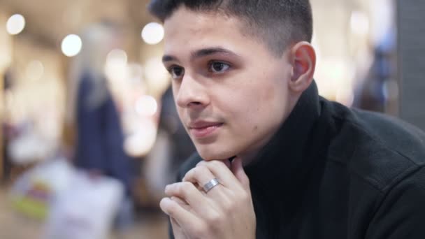 Young Man Sitting Modern Mall Raised Collar Feeling Cold Slo — Stock Video