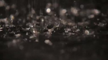 Yağmurlu su göz kamaştırıcı bir mağara rüya gibi su sıçramalarına slo-mo Fab makro çekim yavaş çekimde esrarengiz siyah gölgeler ile bir mağara Arazi doldurma parıldayan yağmurlu boncuk garip noktalar ile arazi. Bir ruh hali bilmece oluşturur.