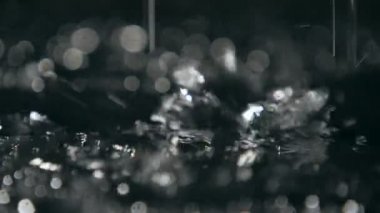 Sihirli noktalar slo-mo soyut makro atış yağmurlu parlayan parlak noktalar ile mağara yüzeyini örten ıslak su sıçramalarına yavaş hareket parlak Siyah gölgeli bir mağara toprak kapsayan. Gizemli bir ruh hali oluşturur.