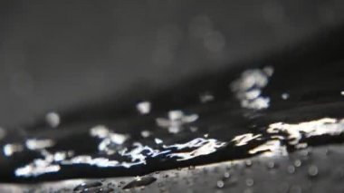 Siyah ve beyaz su akışı sinsi çarpıcı görünüm yavaş çekimde yanardağ lav gibi sanki bir volkan tarama ışıl ışıl siyah beyaz su yıkanmak parlayan ile ve beyazımsı noktalar yavaş hareket. Peri masalı görünüyor.