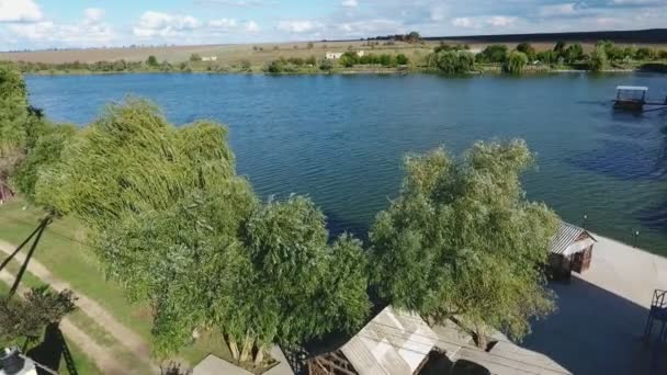 在绿岸和小房子的情况下 用绿色银行和小房子拍摄的鸟图 让人看到了第聂伯罗河的鸟图 绿湖覆盖着高树 小房子和一条乡村道路 — 图库视频影像