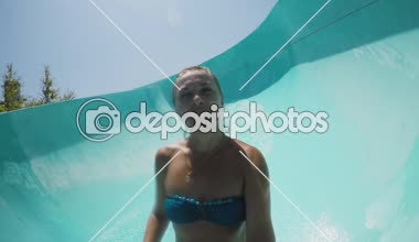 Sürme ve bir aquapark yaz aylarında güneşli bir günde bir aquapark Türkiyede uzun mavi bir tüpte aşağı kayan bikini gülümseyen bir sarışın kadının Türkiye neşeli görünümünde bir selfie alarak mutlu sportif kadın