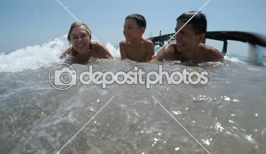 Anne ve iki çocuğunu eğlenceli bir anne ve iki çocuklar gülüyor ve yaz aylarında sıçramasına ve Mısır'daki Kızıl denizin köpürdeyen sular altında yatan bir aileden yaz komik görünümünde Mısır toplama dalgalar altında