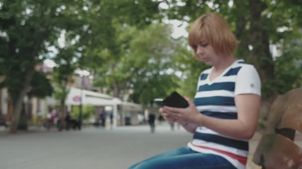 Mulher Loira Confiante Sentada Banco Mensagens Texto Telefone Beco Verde — Vídeo de Stock