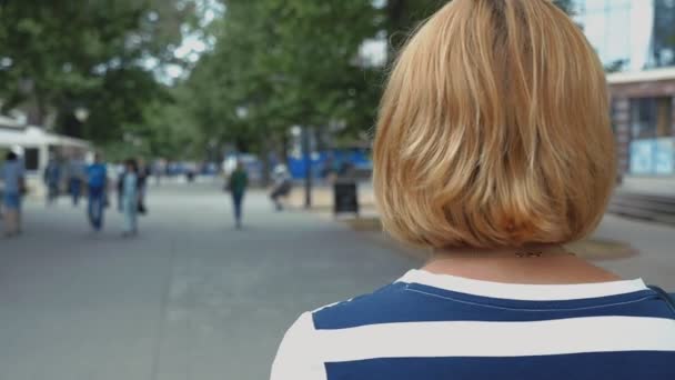 Stylish Blonde Woman Striped Blouse Walking Green Street Summer Back — 图库视频影像