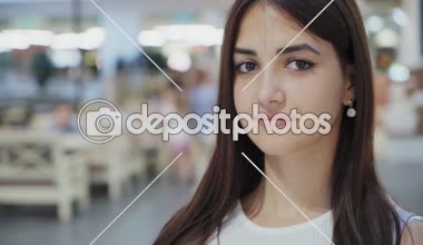 Sınıf kız uzun bağsız kıl ayakta ile top ve büyük bir alışveriş merkezinde yaz güzel portre romantik bir kızın büyük derin gözleri ile gülümseyen, uzun saç ve ayakta ve biraz gülümseyen bir alışveriş merkezinde küçük küpe, gevşek 