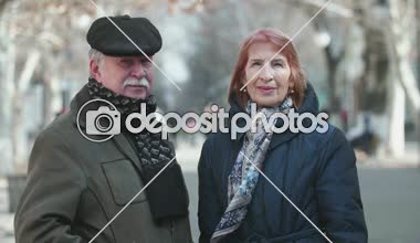 Neşeli yaşlı adam ve yavaş çekimde bir arka sokakta gülümseyen iyimser karısıyla düz kapak ayakta bıyıklı hardy komuta sizde görünümünü Inspiring yavaş çekimde bir parkta duran onun gülümseyen kadın kıdemli