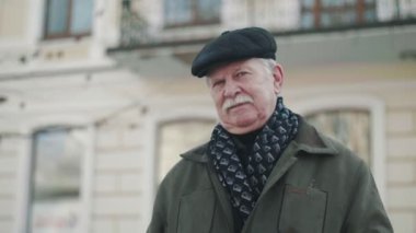 Bir tarihi bir cesur ve openhearted komuta sizde slo-mo neşeli portresi düz kapak ve gülümseyen ve çekimde açık duran yeşil ceket bıyıklı binasında gülümseyen bir düz kapak iyimser beyaz saçlı adam