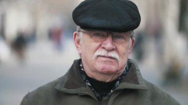 Bir düz siyah kapak ayakta beyaz bıyıklı yavaş hareket şaşırtıcı görünümü düşünceli bir yaşlı adamın sonbaharda bir arka sokakta duran ve bir arka sokakta slo-mo meditasyon düz bir kapak cesur yaşlı adam
