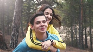 Neşeli esmer kız slo-mo bir çam ormanında onu Hulk arkasında sürme Uzun gevşek saçları ile gülen genç bir kadının duygusal görünümü slo-mo baharda bir köknar ormanda Bay Sağ oturuyor