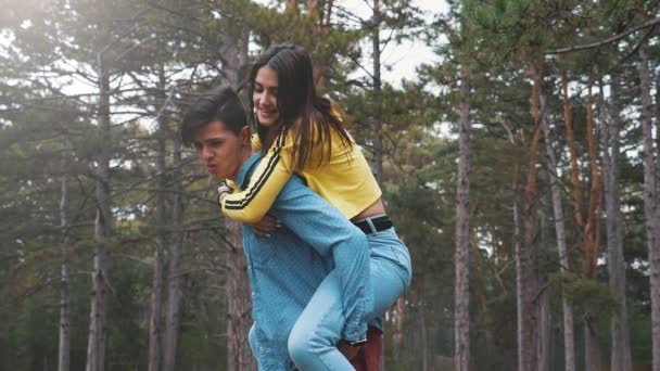 Jovem Alegre Trazendo Sua Doce Garota Costas Uma Floresta Pinheiros — Vídeo de Stock