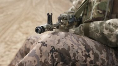 Ak-74 ile haki üniformalı askeri adam ilkbaharda bir ülke yolda modern bir Zırhlı personel taşıyıcı sürme Ak-74 saldırı tüfeği ile haki üniformalı bir askerin baharda alanında bir gidiş Apc üzerinde oturan