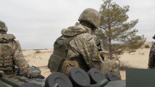 乌克兰军人与Ak 74突击步枪骑着Apc在春天的田野上引人注目的乌克兰士兵在卡其制服和Kevlar战斗头盔坐在移动的Apc在一个无边无际的田野在阳光明媚的一天 — 图库视频影像