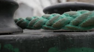 Mavi plastik halat bahar da açık havada iki metalik makaralar arasında acele Standart olmayan bokeh closeup mavi örme halat ilkbaharda arka planda bir çalı ile açık havada hareket