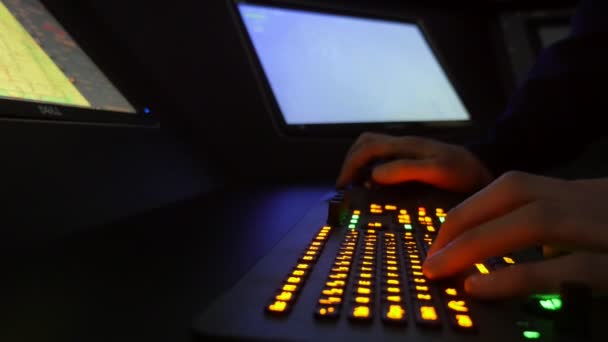 海軍将校は いくつかの大きなコンピュータ画面を持つ貨物船の近代的なダッシュボード上の黄色のボタンを押す海軍将校の手の壮大なプロファイルを持つ貨物船のダッシュボード上の黄色のボタンを押します — ストック動画