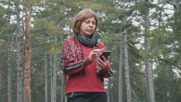 Gedesoriënteerde Vrouw Draait Rechts Links Met Haar Telefoon Hout Slo — Stockvideo