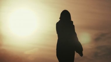 Mutlu kadın dans ve zarif gün batımında iplik slo-mo duygusal ilkbaharda arkadan görünüşü dans ve etrafında dönen bir horizonless alanında bahar yavaş çekimde bulanık bulutlu gün batımında zarif bir kadın