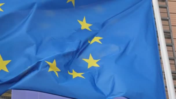 1つのEuフラグ ヨーロッパ同盟のエンブレム 春にブリュッセルで手を振る青い背景と春の晴れた日にブリュッセルで12の星を持つ1つの欧州連合のバナーの感動的な眺め — ストック動画