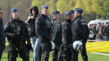 Brüksel, Belçika - 30 Mart 2019: Baharda güneşli bir günde sokakta insanları koruyan yem kapakları ve siyah üniformalarla gülümseyen Belçika polis memurlarının olumlu görünümü
