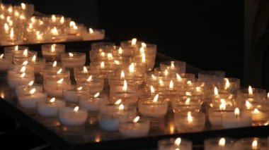 Yavaş çekimde Bruges'teki bir Katolik kilisesinde yüzlerce açık hava mumu, brugge'deki katolik bir Hıristiyan kilisesinde yakılan çok sayıda açık hava mumunun dini görünümünde. Güzel ve ebedi görünüyorlar..