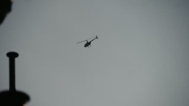 Polis helikopteri gökyüzünde uçan ve slo-mo modern bir polis rotor uçağı slo-mo Arty görünümünde bir Belçika sokakta bir sokak ışığı bulutlu gökyüzünde yüksek ve slo-mo bir Bruges sokakta retro tarzı sokak ışığı yüksek yükselen