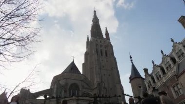 Büyük Gotik bina ve Brugge bir tekne den insanlarla bir köprü açıklık yüksek kuleleri ve weathercocks, bir köprü açıklıklı büyük bir Gotik binanın görünümüaşağı Brugge kanal kıyısında insanlar 