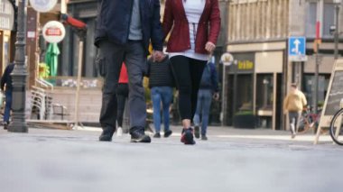 Brüksel, Belçika - 1 Nisan 2019: Slo-mo'da ilkbaharda Belçika'da eski tarihi binaların yer verdiği arnavut kaldırımlı bir sokakta insanların ayaklarının tadını çıkarmanın sanatsal görünümü