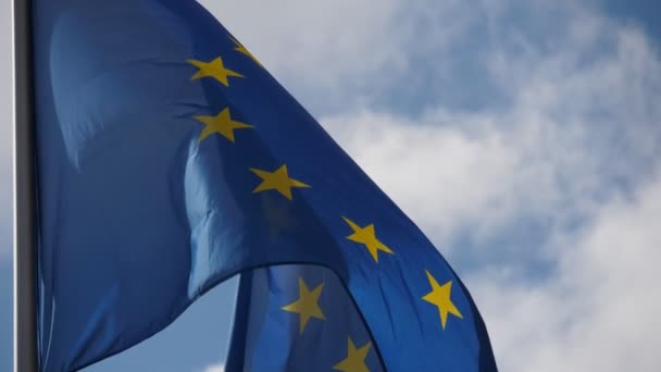 Euの旗 民主主義と自由のしるし 青い背景と星の円が誇らしげに揺れる欧州連合の旗の豪華な眺めで旗の上を飛ぶ — ストック動画