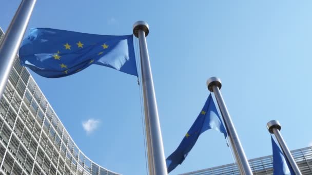 自由欧盟的旗帜飘扬在欧盟委员会在塞莱斯特的天空在Slo Mo向下的欧盟横幅与蓝色背景和金色的星星挥舞着现代和玻璃官方的Ec房子在春天在Slo — 图库视频影像