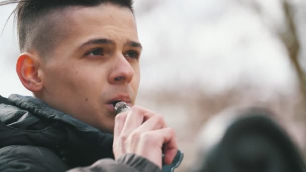 Joven Elegante Moreno Fumando Cigarrillo Electrónico Aire Libre Parque Primavera — Vídeo de stock