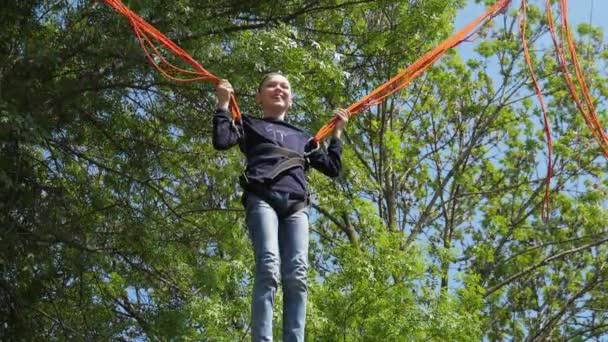 Jolly Jongen Springen Een Trampoline Met Handen Het Houden Van — Stockvideo