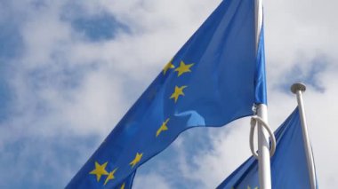 İlkbaharda Brüksel'de altın yıldızlarla serbestçe dalgalanıyor iki Avrupa Birliği bayrağı, hukukun üstünlüğü ve demokrasinin sembolleri, ilkbaharda göksel bir gökyüzünde gururla çırpınan iki Avrupa Birliği bayrağı