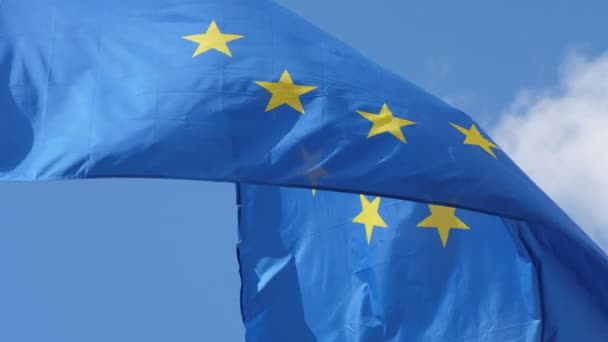 春にブリュッセルの旗柱に厳粛に揺れる民主的なEuの旗は 晴れた日にブリュッセルの金属製の旗柱に誇らしげに手を振る巨大な欧州連合の標準の素晴らしい眺め — ストック動画