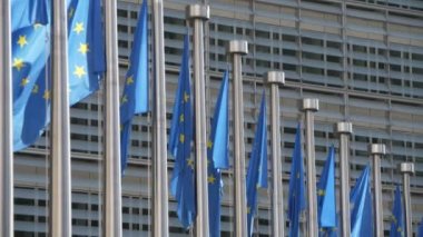 Avrupa Parlamentosu 'nun bayrak direkleri, yavaş çekimde dalgalanan bayrak direkleri mavi arkaplanlı ve altın yıldızlı Eu bayraklarının yavaş çekimde Ep binasındaki yüksek bayrak direkleri üzerinde sallanışını görmektedir. 