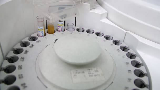 特殊ラボで血液検査用医療機器の一部としてリールに乗り 穴が回り 血液分析のための特別な実験室で一時停止を行う円形コイルの豪華なクローズアップ — ストック動画