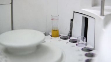 Kan testi ve uzman elleri için tıbbi ekipman bir parçası olarak Yuvarlak makara Özel bir laboratuvarda delikleri ile dairesel bir bobin içinde kan boruları yerleştirerek beyaz eldiven tıp uzmanının ellerini çarpıcı yakın çekim