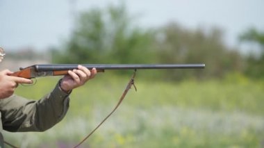 Adam yavaş çekim de skeet çekim pratik yan yana tüfek çekim Yavaş çekim güneşli bir günde kil güvercinler hedefleyen bir çift namlulu tüfek tutan akıllı bir adamın Muhteşem closeup
